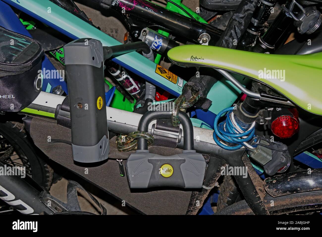 Biciclette, saldamente bloccato con Yale venduto serrature oro sicuro Foto Stock