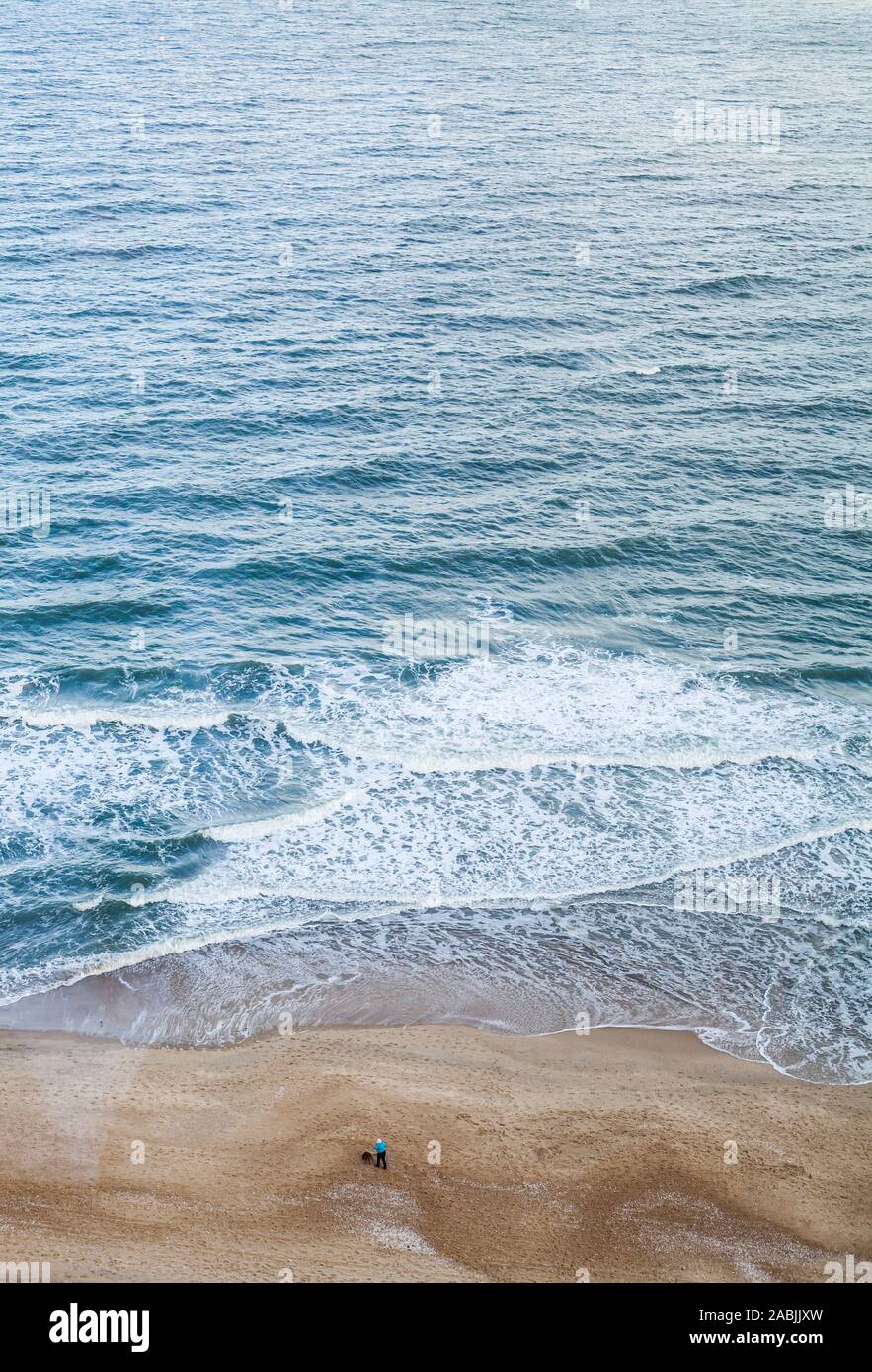 Una donna che cammina il suo cane sulla spiaggia, Ocean City, Maryland, Stati Uniti d'America. Foto Stock