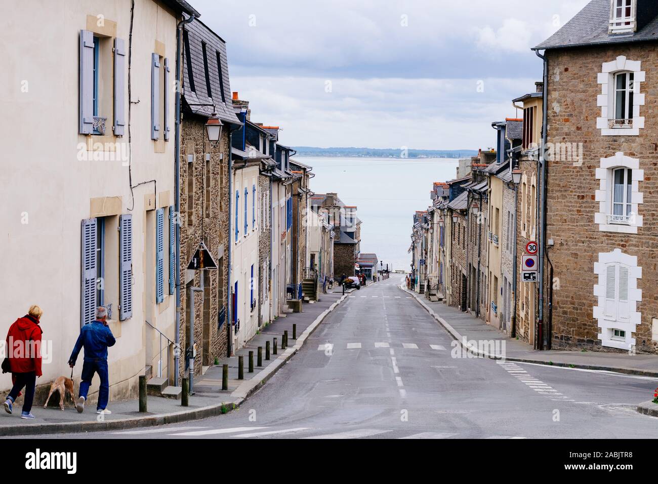 Vista su Rue du Port nella cittadina di pescatori di Cancale, Bretagna, guardando verso il mare e St-Benoît-des-Ondes. Foto Stock