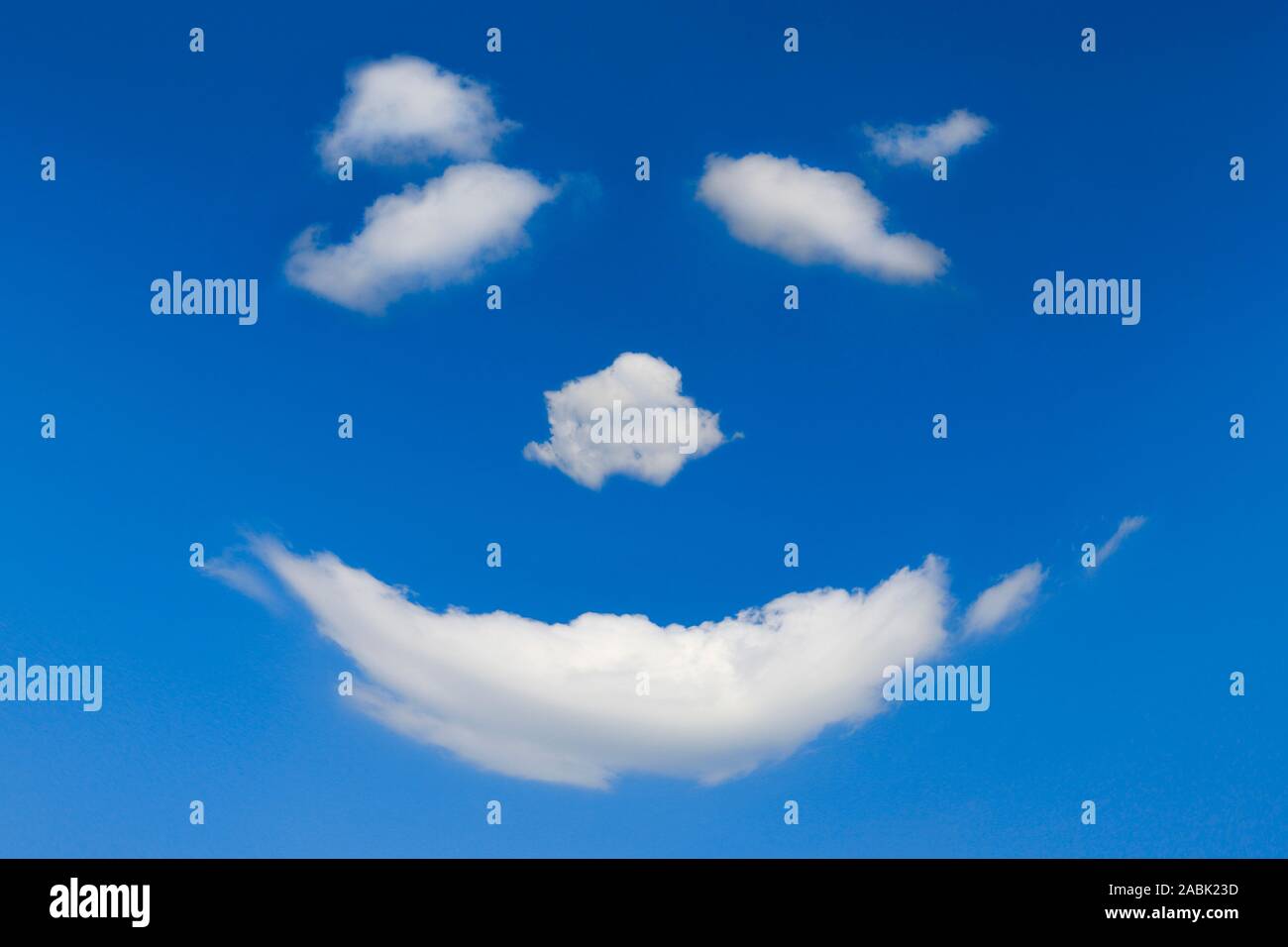 Una faccia felice fatta di nuvole nel cielo blu Foto Stock