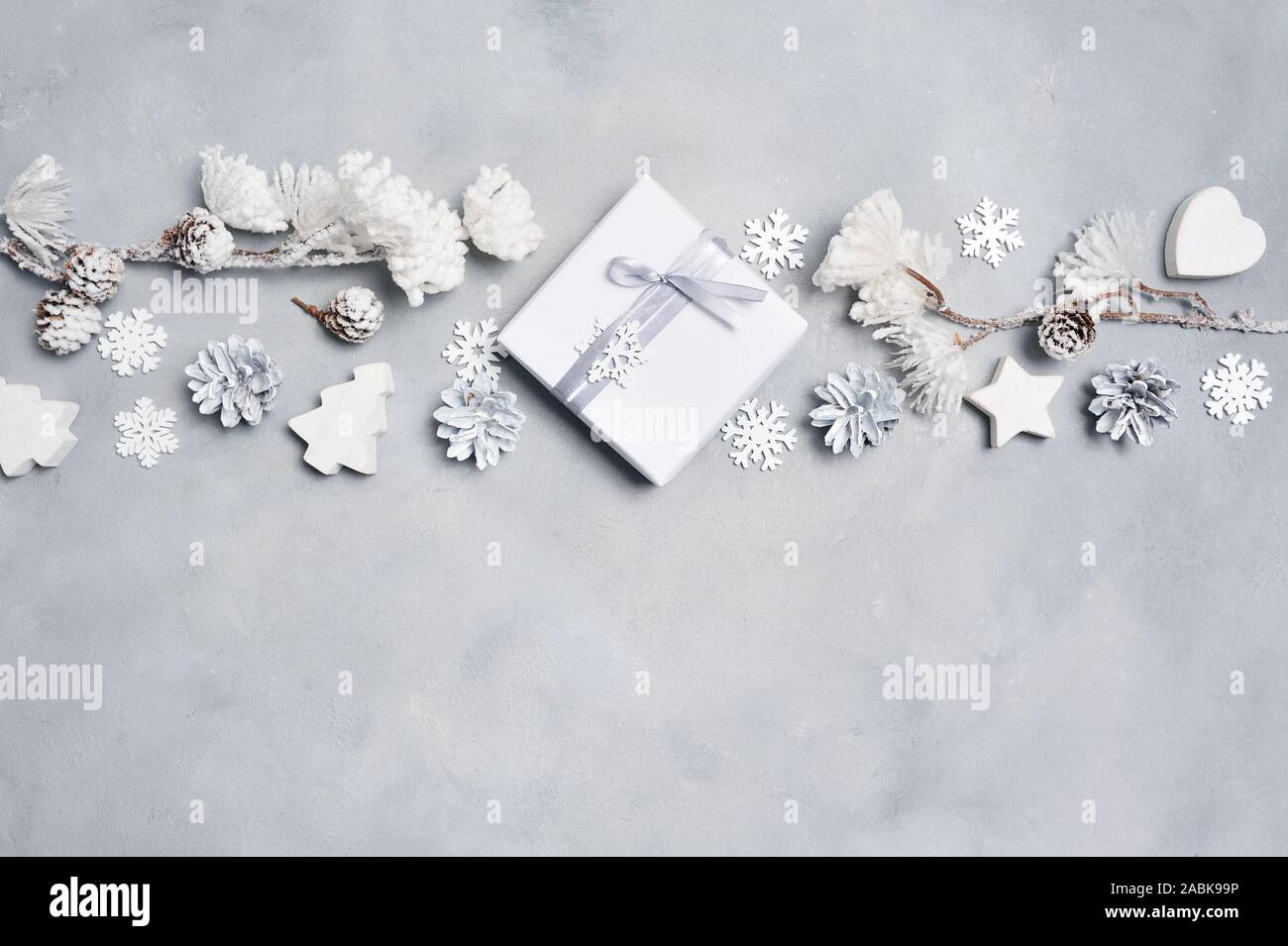 Progettazione di frontiera un Natale biglietto di auguri con il Natale regalo, coni, cuore, i fiocchi di neve con posto per il vostro testo. Decorazioni su un legno bianco Foto Stock