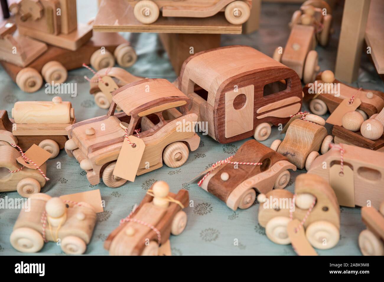 Vecchio legno eco friendly giocattoli per bambini visualizzati su un tessuto di colore blu. Nessuna materia plastica utilizzata. Vecchio vintage materiali utilizzati in un nuovo modo. Auto e veicoli di Foto Stock