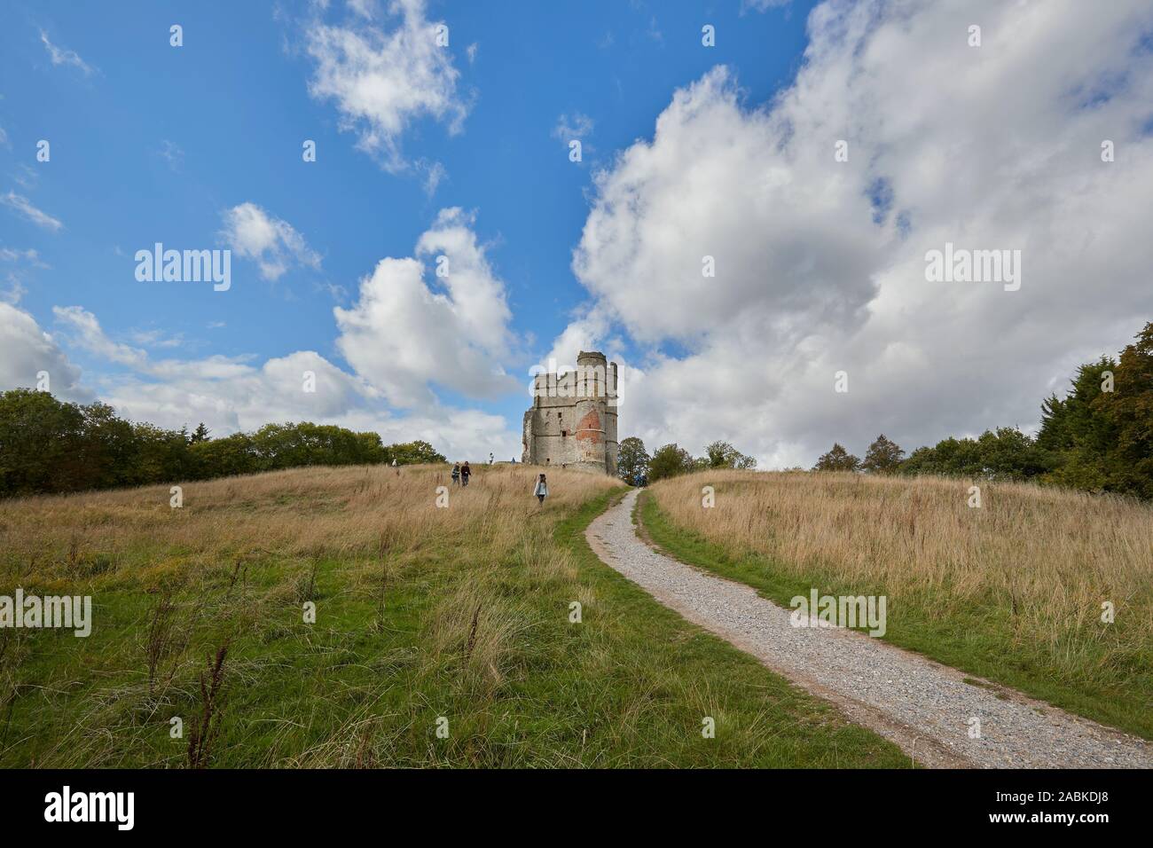 Un gruppo di persone che visitano il Castello di Donnington con nuvole bianche striature sopra la parte superiore su una giornata d'estate, Newbury, Berkshire, Regno Unito Foto Stock