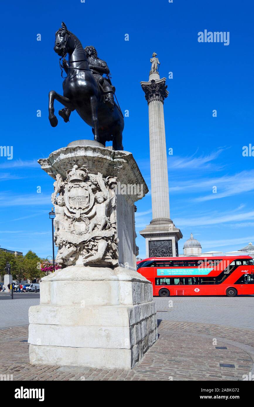 Londra, Inghilterra, Regno Unito. Nelson la colonna, statua di Carlo I e rosso autobus a due piani a Trafalgar Square Foto Stock
