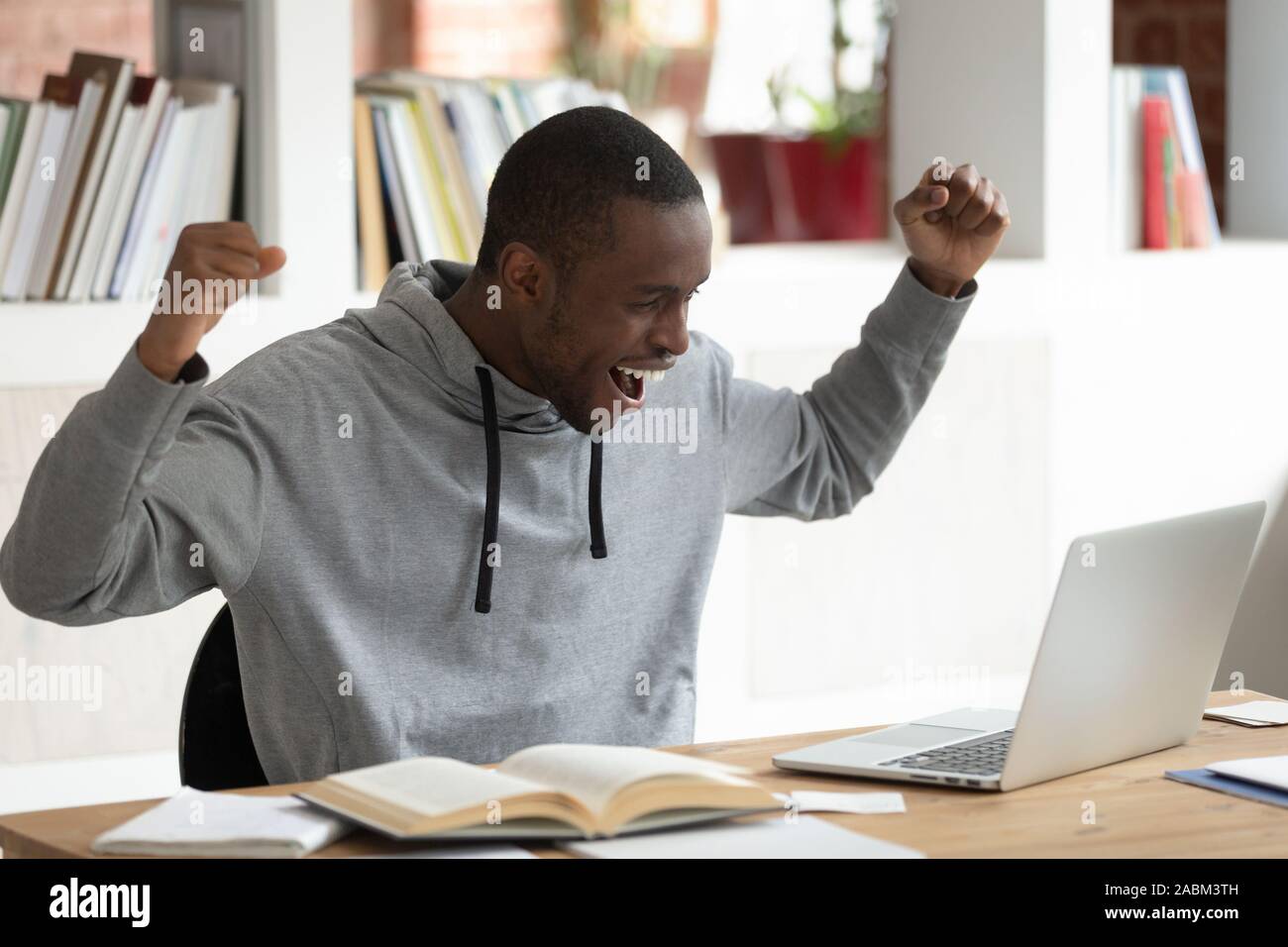 Overjoyed giovane americano africano studente maschio celebrando buoni risultati esame. Foto Stock
