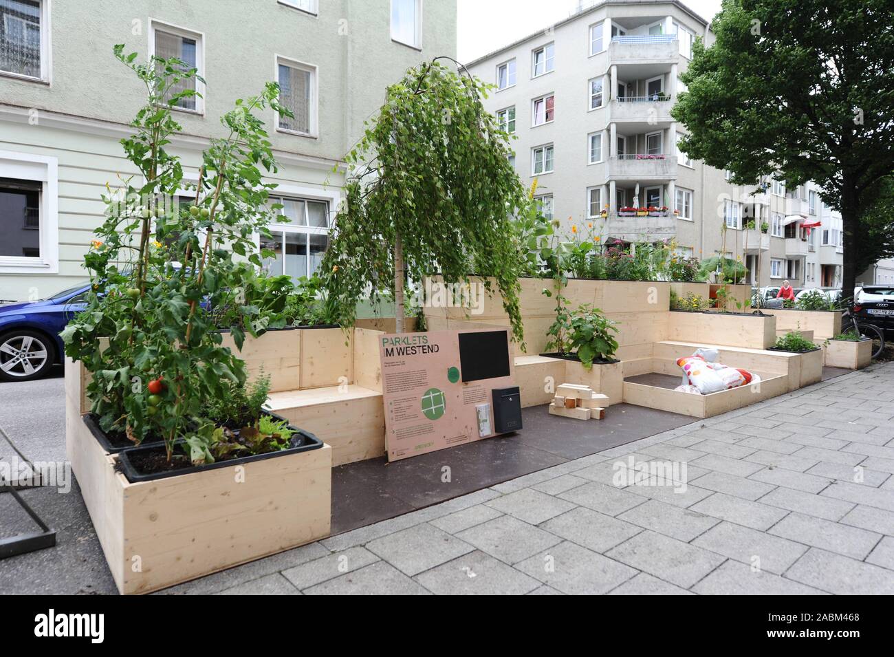 Come parte di un progetto pilota, la città verde iniziativa ambientale a Monaco di Baviera il West End è impostazione libera terrazze all'aperto sul ciglio della strada per due mesi. Il dazio "Parklets' sono con vegetazione e vi invita a sedervi e soffermarsi. [Traduzione automatizzata] Foto Stock