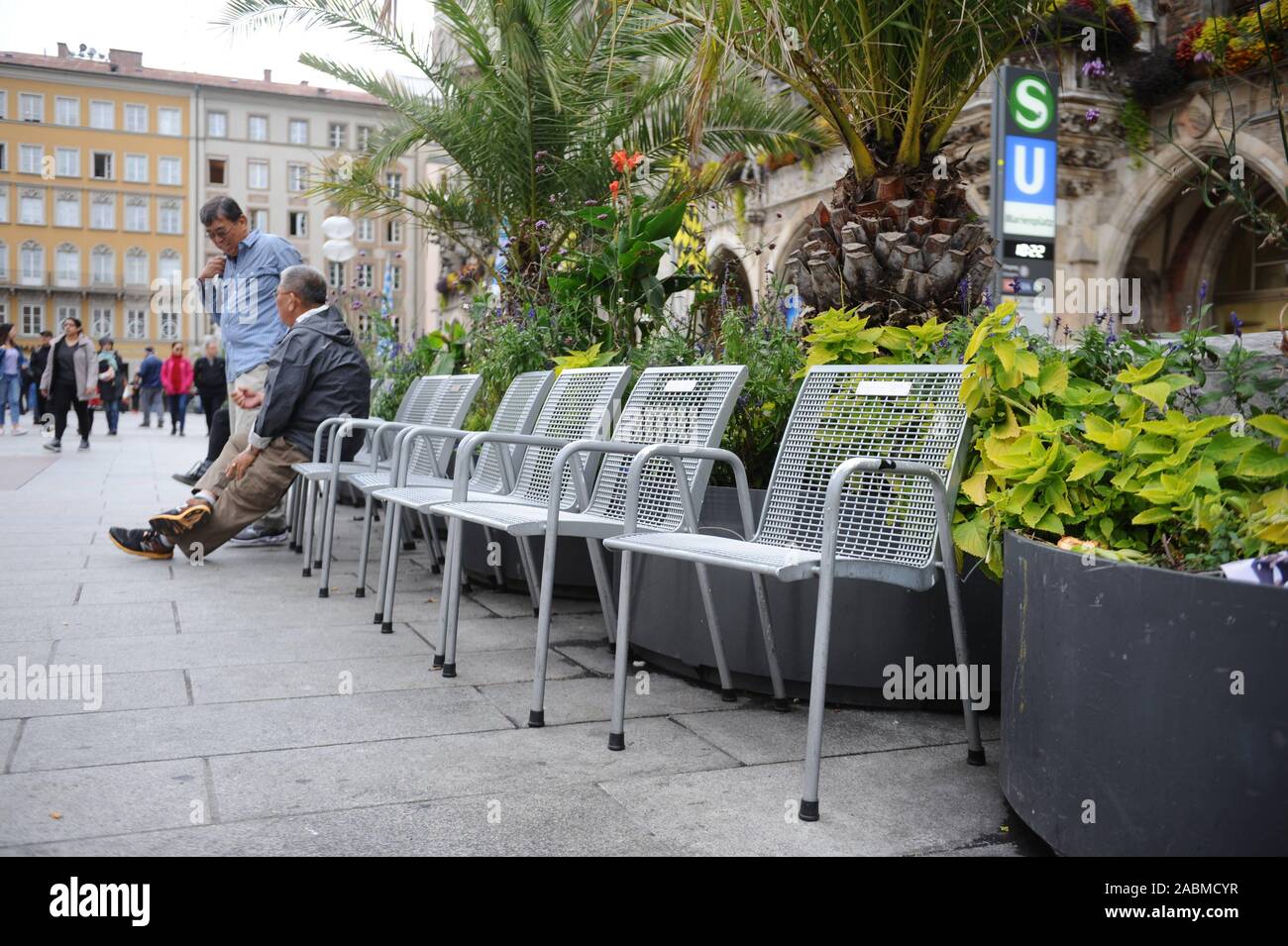 Per la maggior parte delle sedie vuote sotto le palme su Monaco di Baviera Marienplatz. [Traduzione automatizzata] Foto Stock