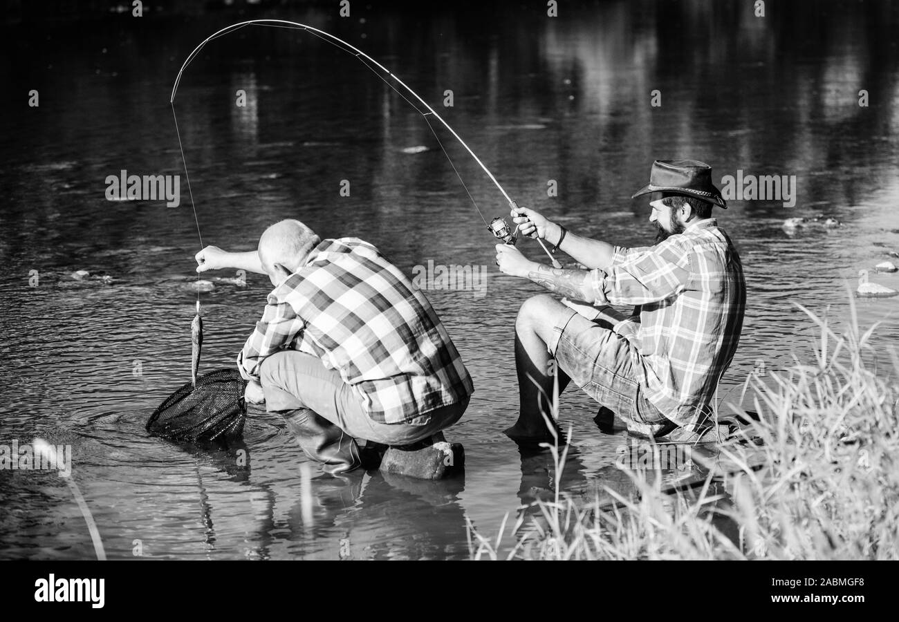 Due amici maschi la pesca insieme. pensionato padre e matura figlio barbuto. felice amicizia dei pescatori. fly fish hobby di uomini. Pensione di pesca. Big game pesca. Rilassatevi sulla natura. È così grande. Foto Stock