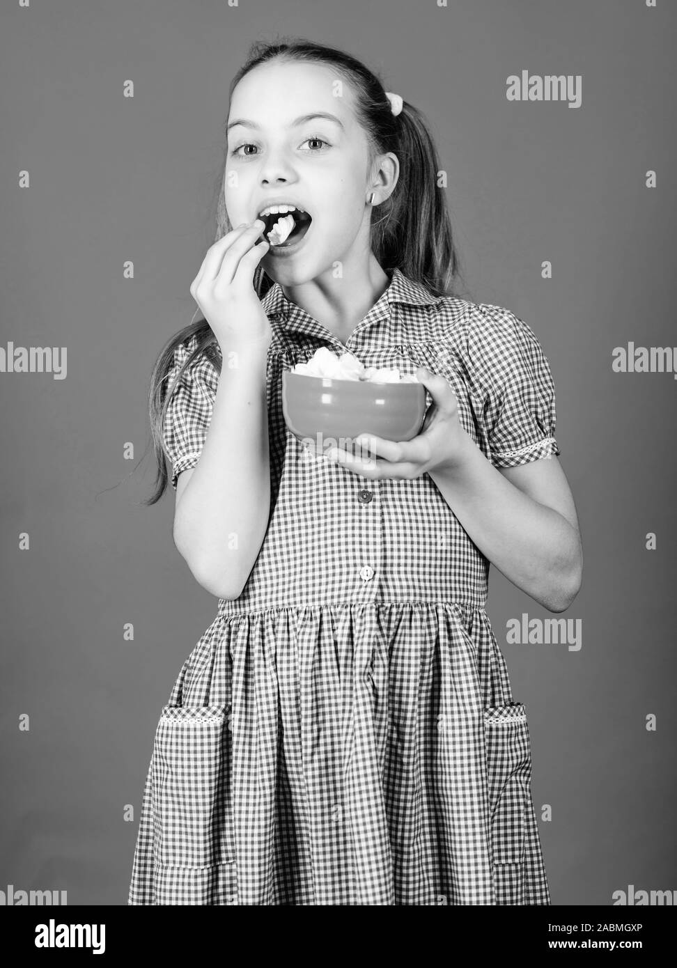 Piccola ragazza mangiare marshmallow. Diete e calorie. Sweet Tooth concetto. piccolo felice bambino amore dolci e delizie. Cibo sano e per le cure dentarie. marshmallow. Negozio di dolciumi. Il cibo sano è la vita sana. Foto Stock