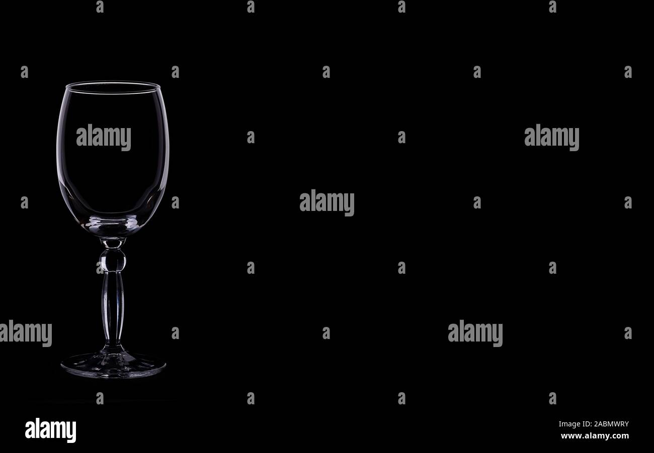 Vino brillante silhouette di vetro isolato su uno sfondo scuro. Modalità Buia. Foto di cibo per banner. Zero Gravity. Concetto di vendita, prezzo scontato. Foto Stock