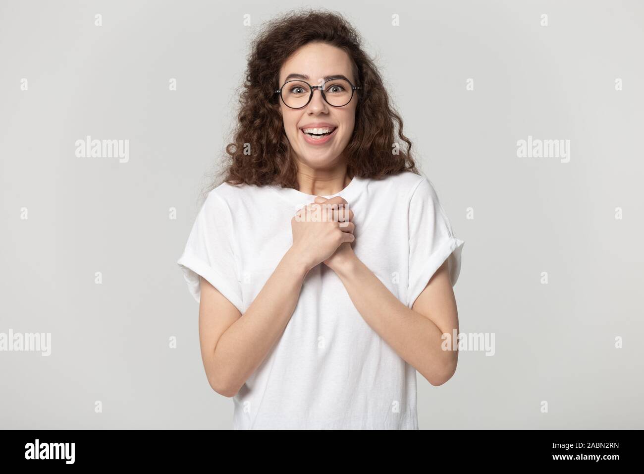 Eccitato ragazza millenario in bicchieri sento contentissimo con notizie Foto Stock