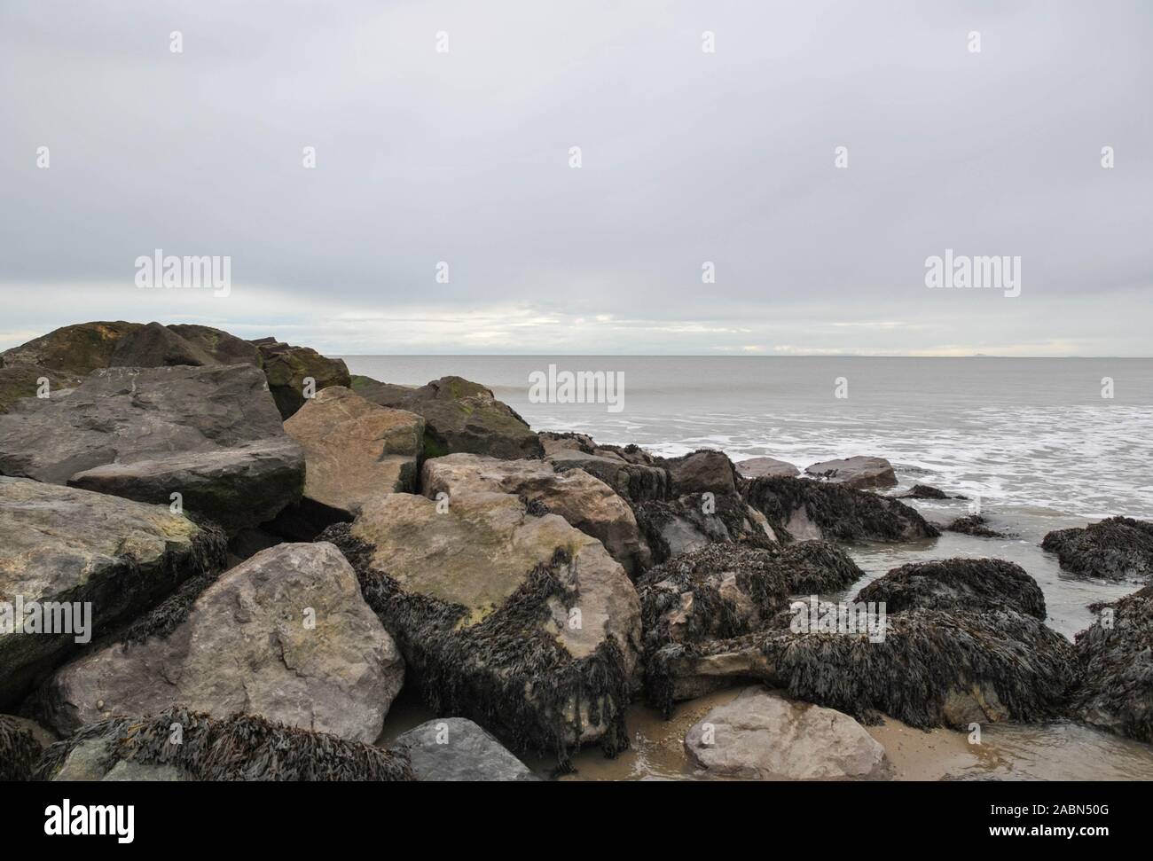 Massi su una spiaggia contro un cielo grigio Foto Stock