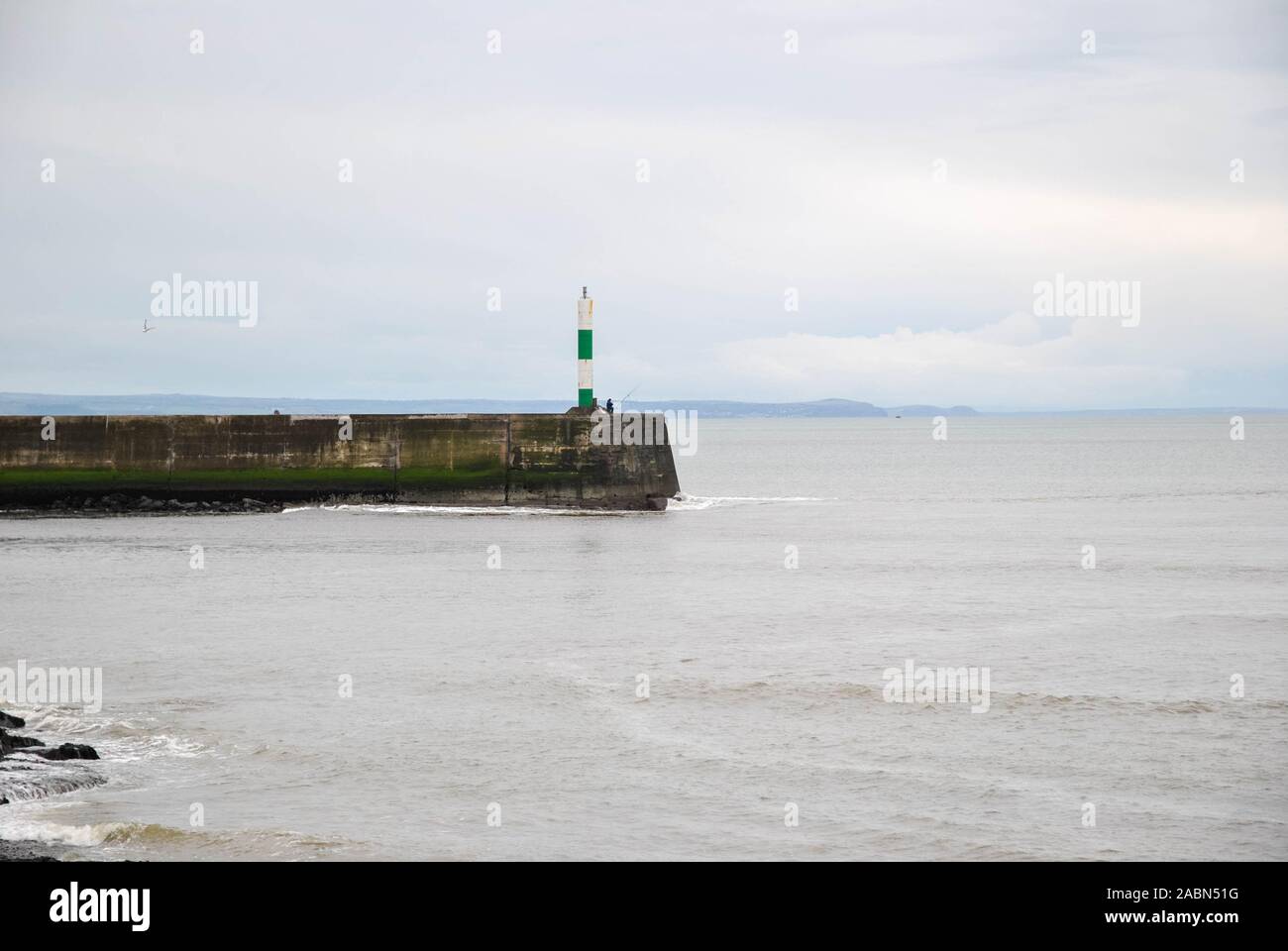 Aberystwyth Harbour parete che mostra il faro e Fisherman Foto Stock