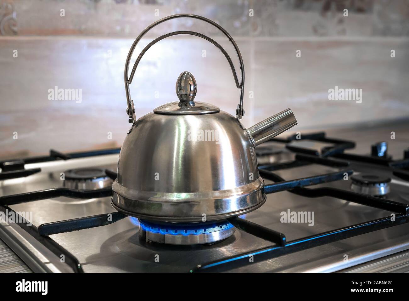 Bollitore in acciaio su un fornello a gas, cucina casalinga, bollire acqua  per il tè Foto stock - Alamy