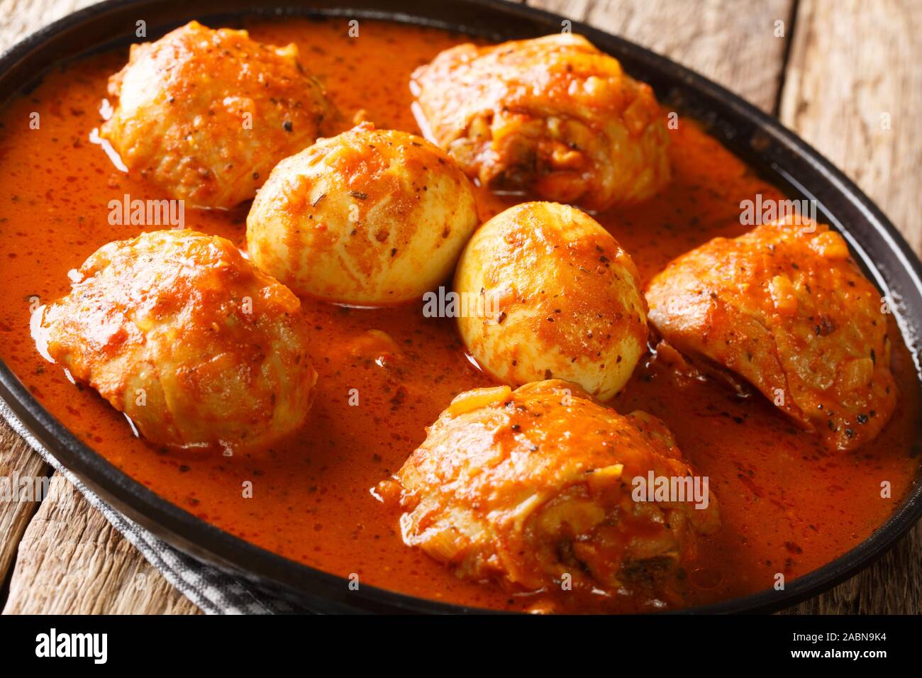 Doro Wat è stufato etiope di cosce di pollo con le uova in una salsa piccante di close-up in una piastra sul tavolo orizzontale. Foto Stock