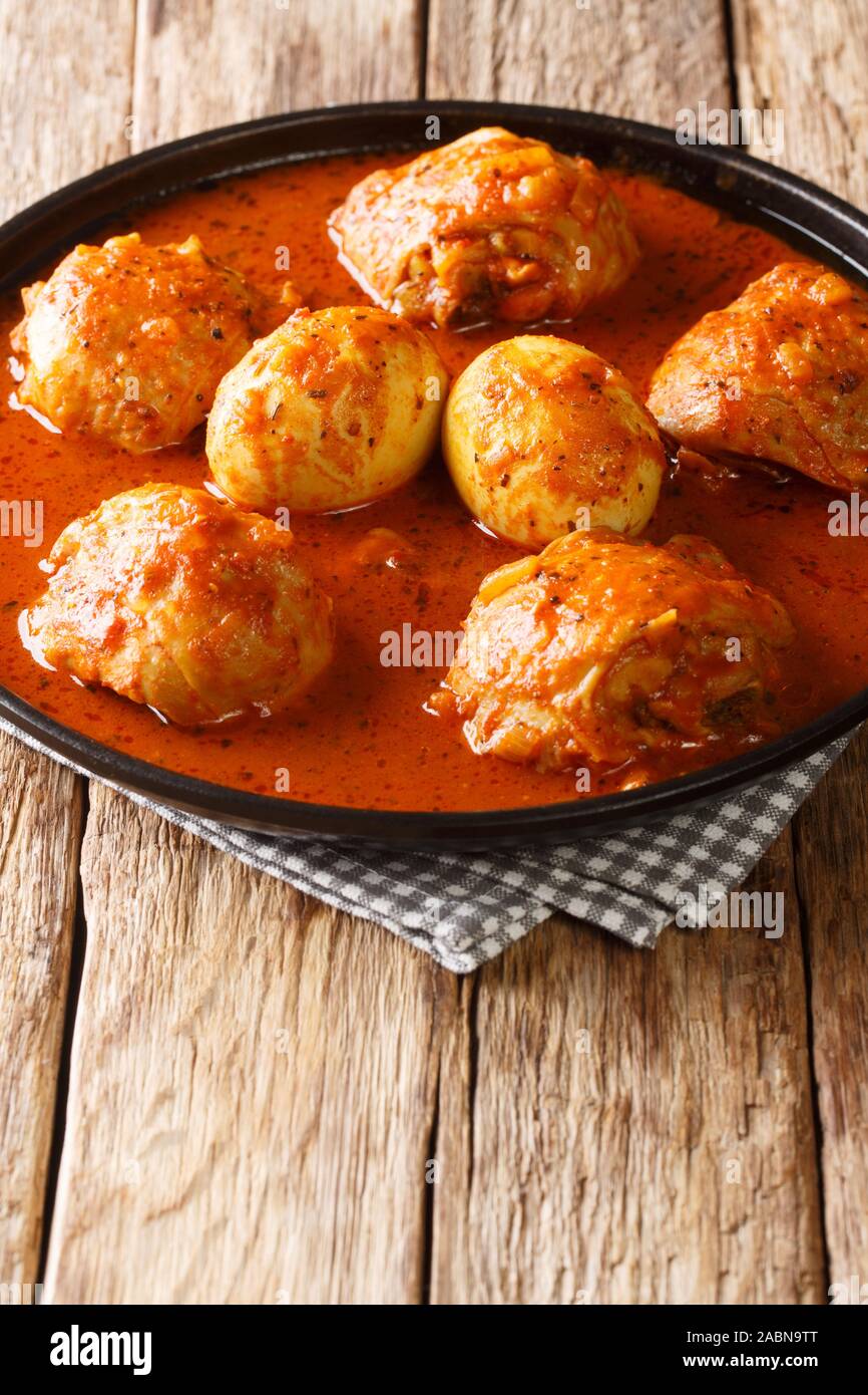 Il cibo Etiope Doro Wat di pollo con le uova in una salsa piccante di close-up in una piastra sul piano verticale. Foto Stock