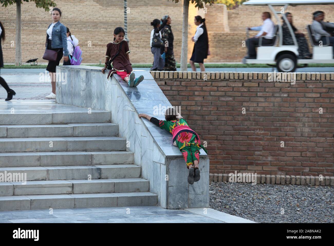 Giovani ragazze zingare giocando al di fuori della moschea Bibi-Khanym in Samarcanda Foto Stock