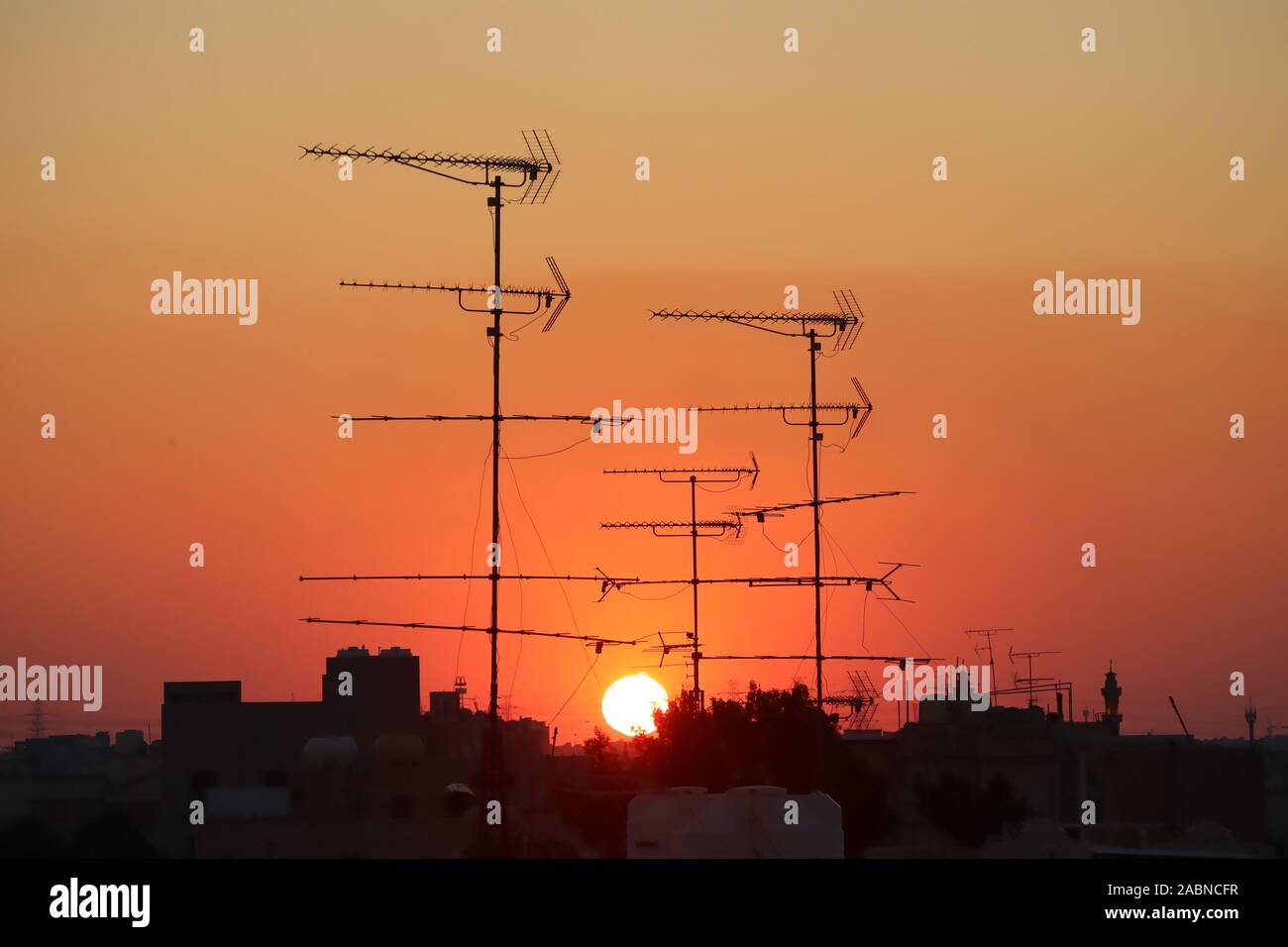 Antenna televisione stagliano contro una regolazione del sole Foto Stock