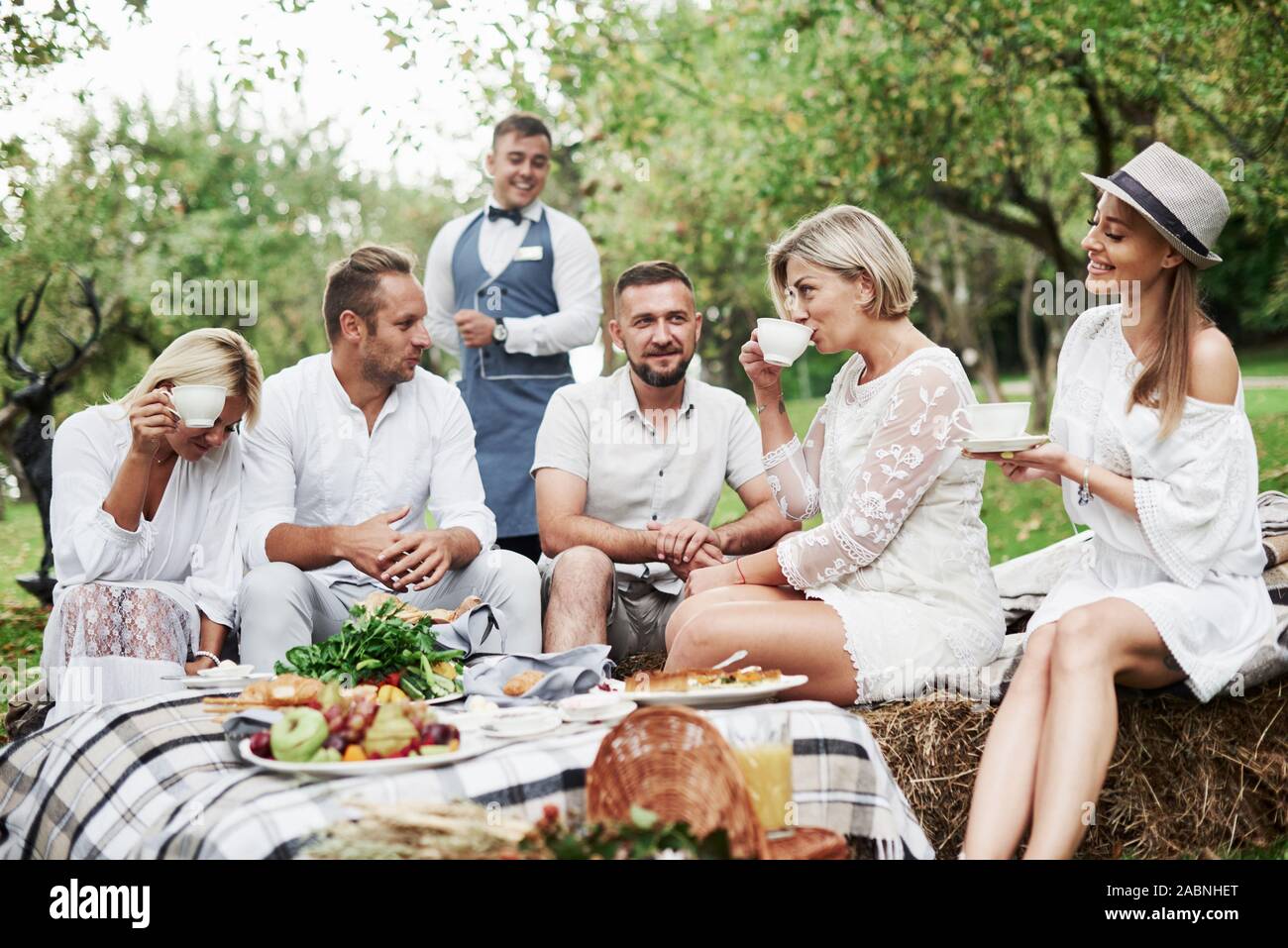 Stato d'animo gioioso. Gruppo di amici adulti hanno un resto e la conversazione nel cortile del ristorante a cena Foto Stock