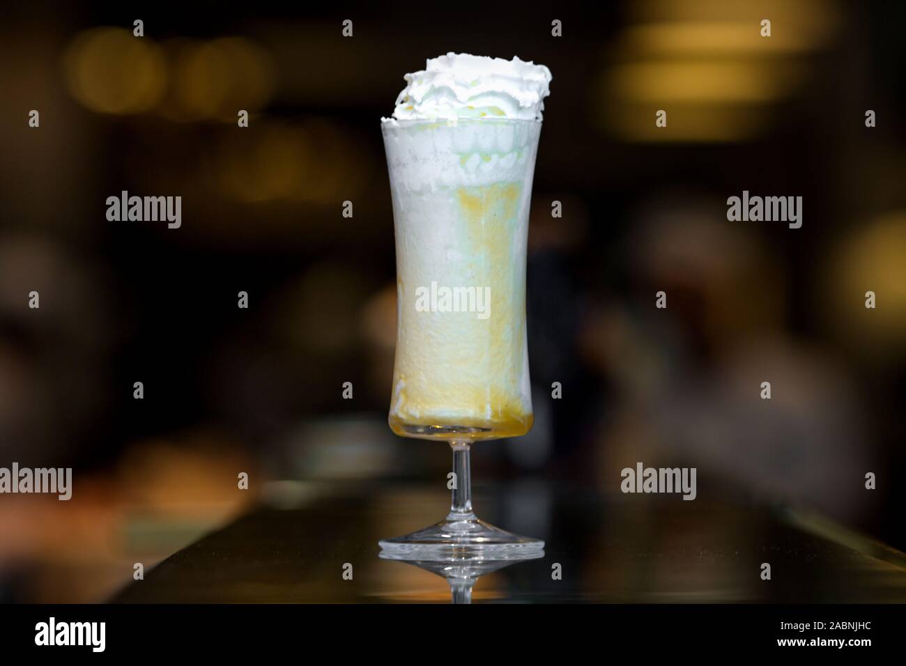 Frullato di colore arancione con la panna montata in un lungo il vetro Foto Stock