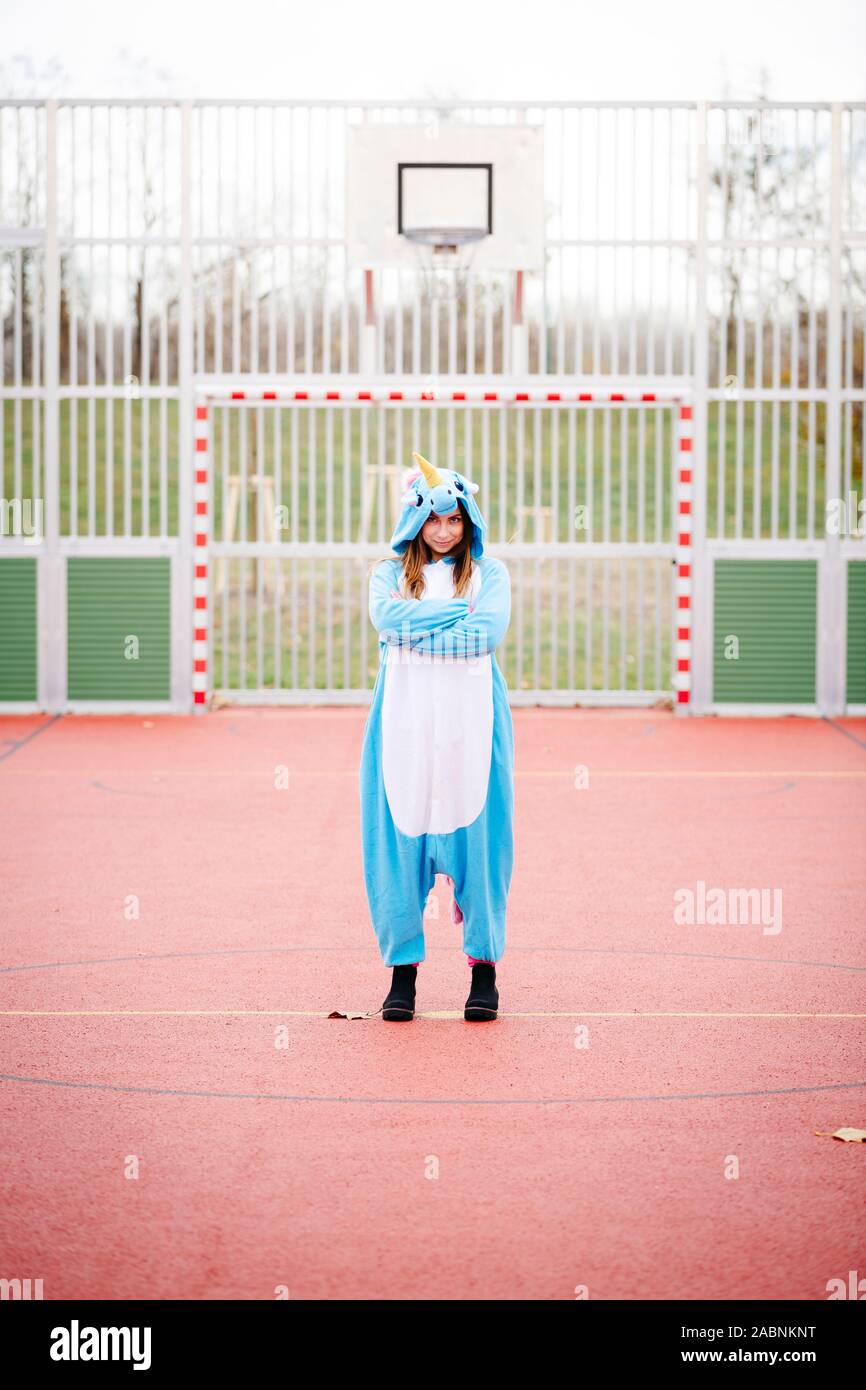 Giovane e bella donna che indossa il turchese unicorn onesie in ambiente urbano Foto Stock