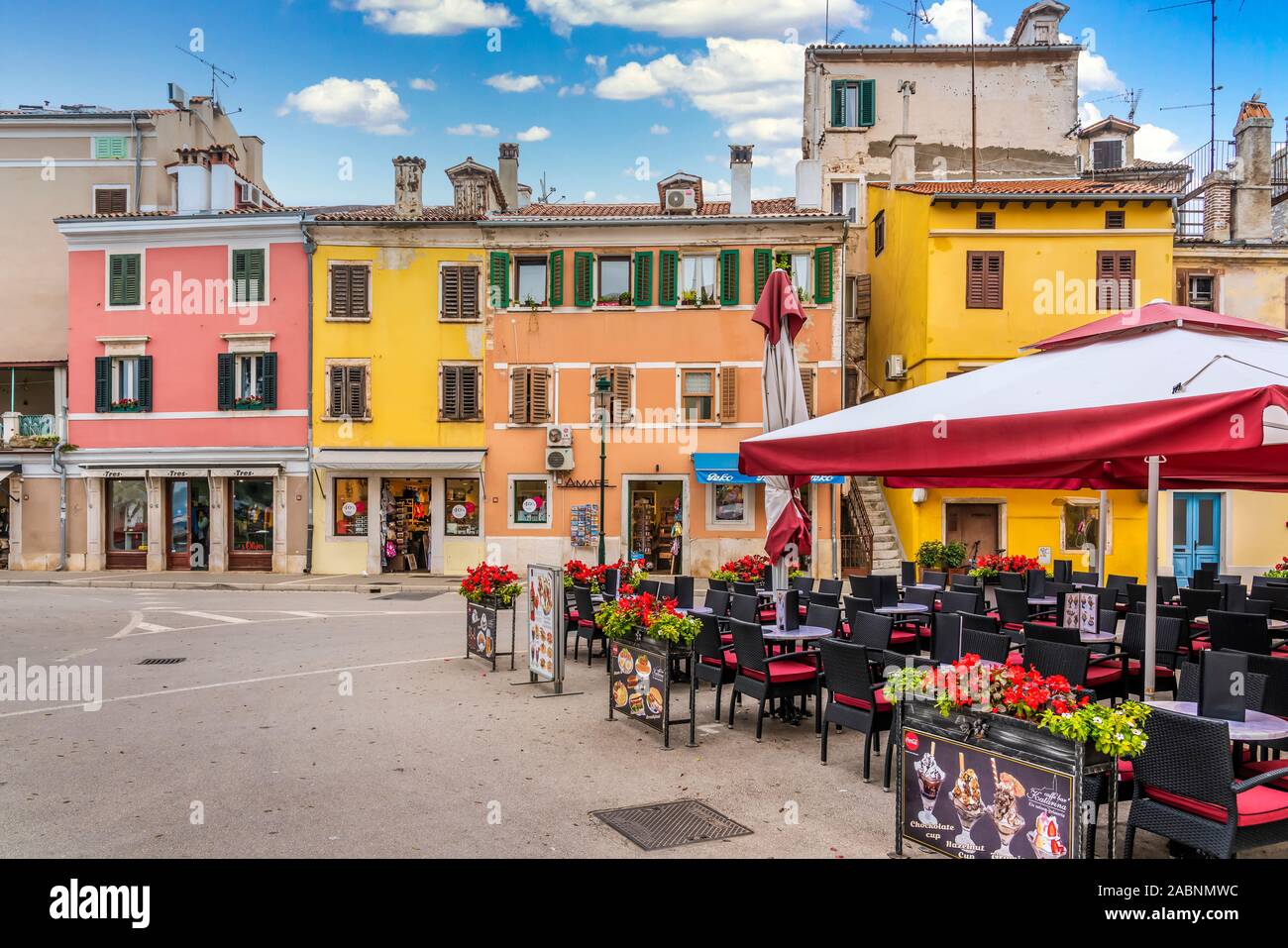 Una strada con i suoi edifici colorati e un ristorante all'aperto a Rovigno, Croazia, Istria. Foto Stock