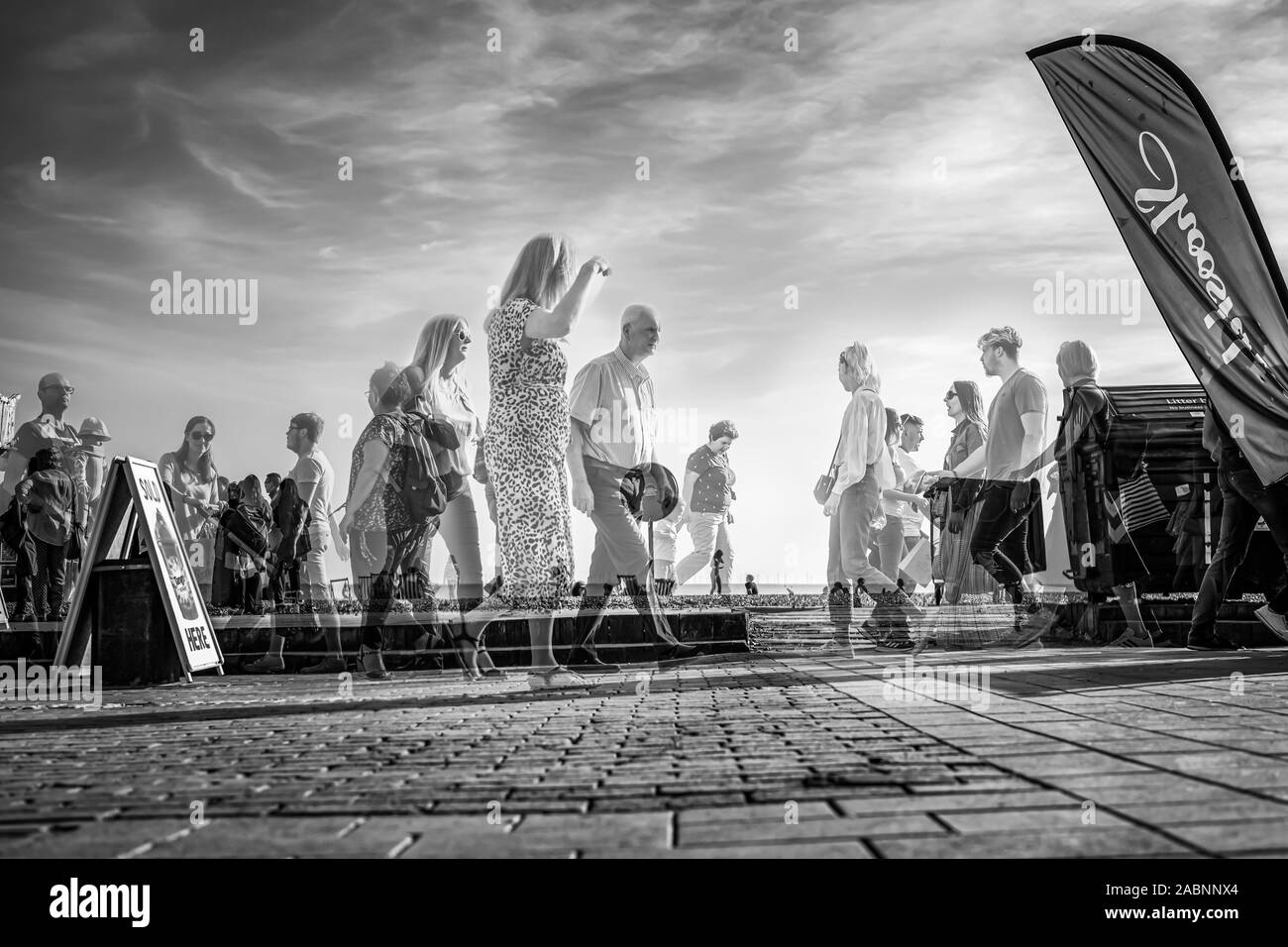 Gruppi di persone che passeggiano lungo la Brighton Seafront in estate sole Foto Stock