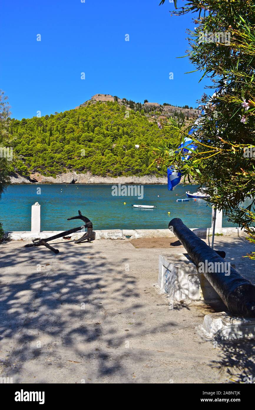 Una banchina di vista sul porto di Assos verso l'antica collina del castello/ fortezza. Vecchio canonico e il dispositivo di ancoraggio in primo piano. Foto Stock