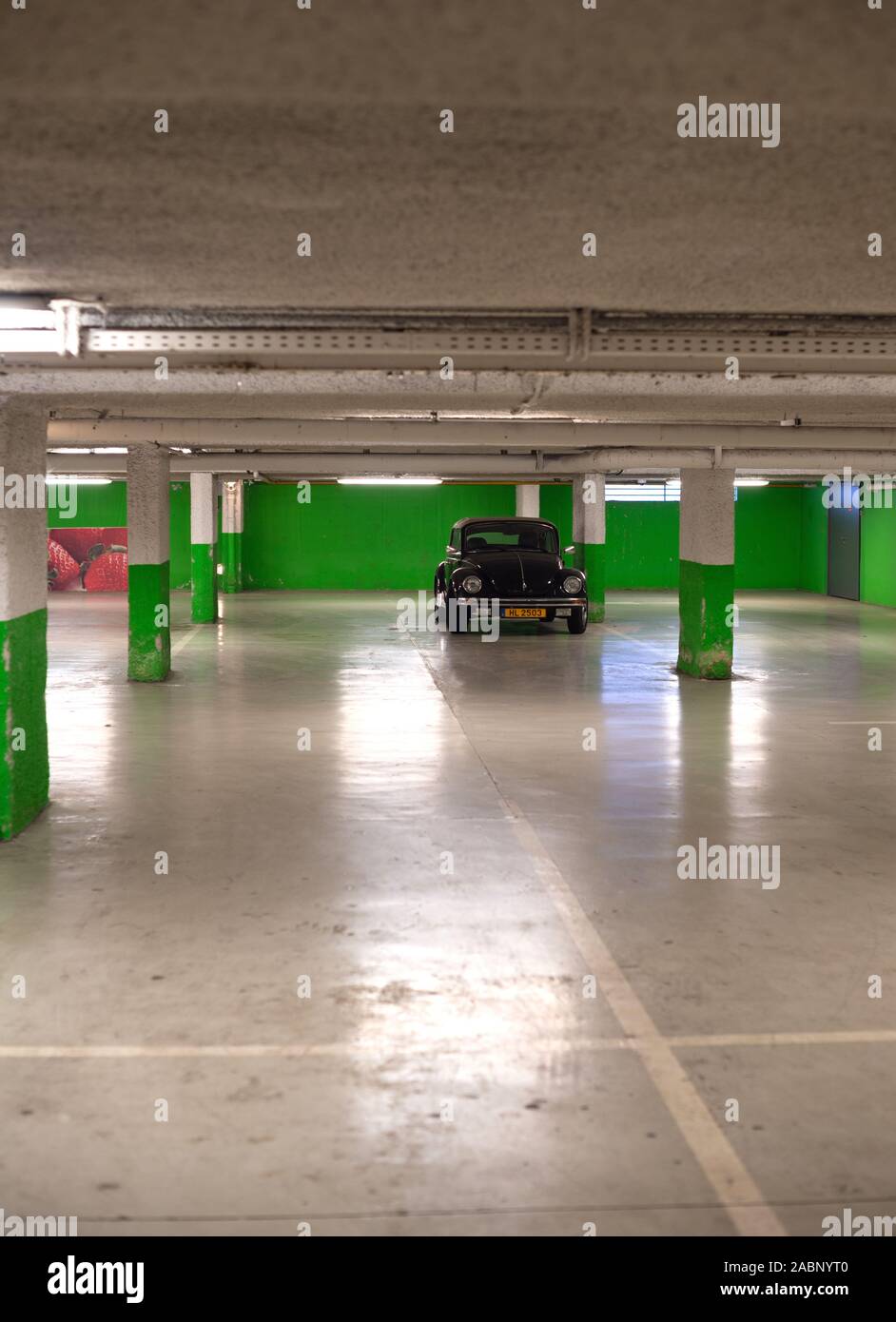 Strasburgo, Francia - Dic 21, 2016: verticale immagine di nero trasformabile cabriolet Volkswagen maggiolino mini auto parcheggiate nel sotterraneo vuoto parete verde parcheggio Foto Stock