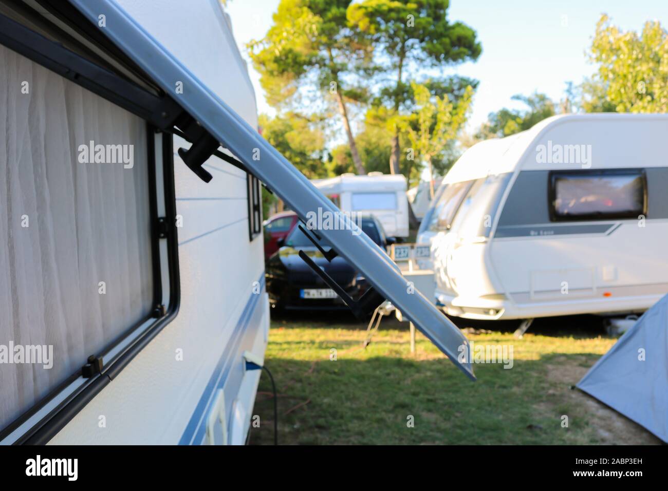Aprire la finestra di un rimorchio campeggio in piedi su un campeggio nel nord della Spagna, vicino a Sant Pere Pescador. White Mobil home in campeggio Foto Stock