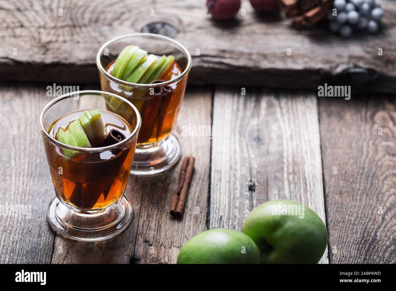 Natale tradizionale riscaldamento invernale cocktail, rimuginassero sidro di mela bevanda con bastoncini di cannella, bevande in bicchieri rustico sul tavolo di legno, close up Foto Stock