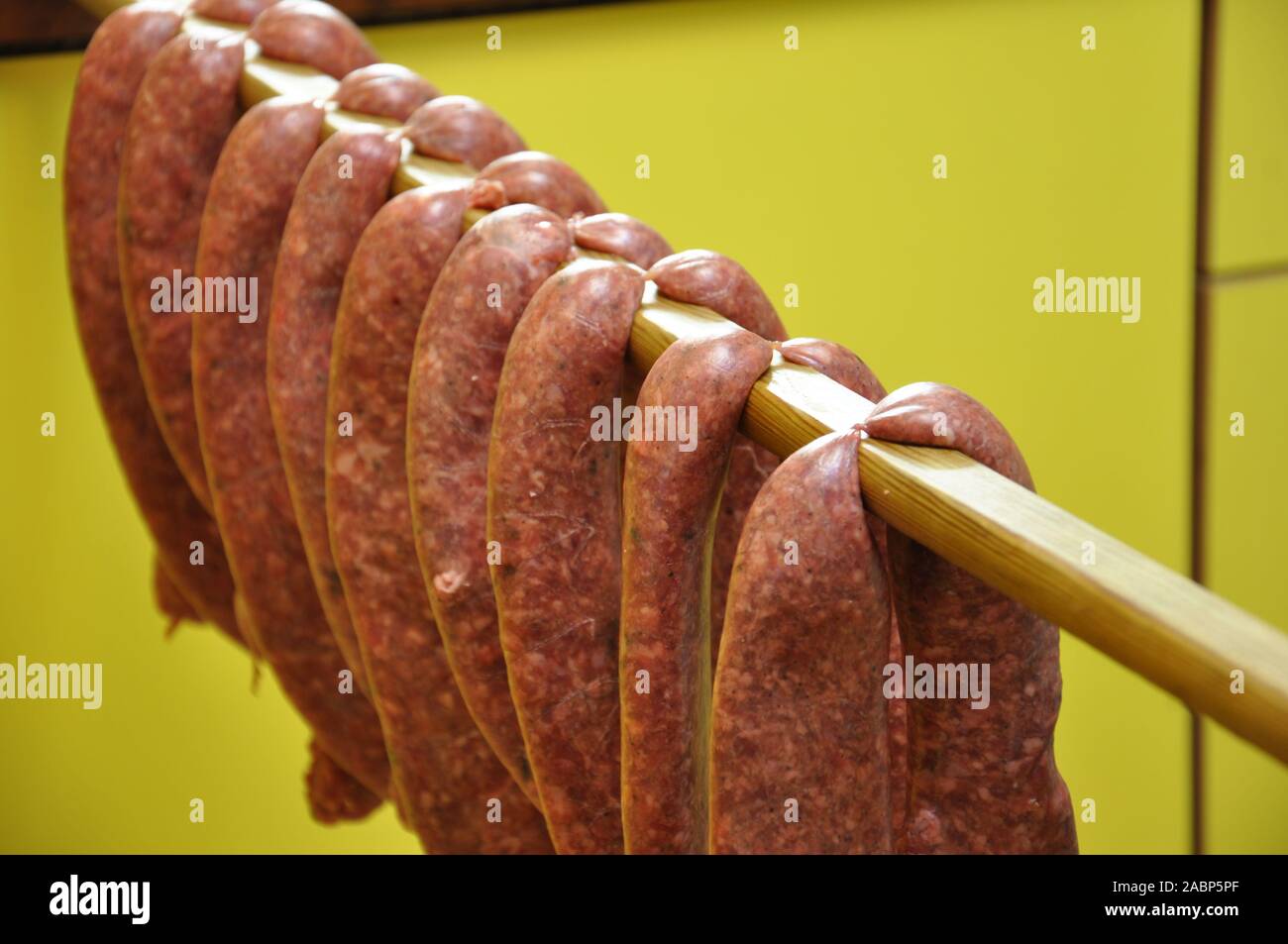 Una fila di salumi crudi che viene indurito Foto Stock