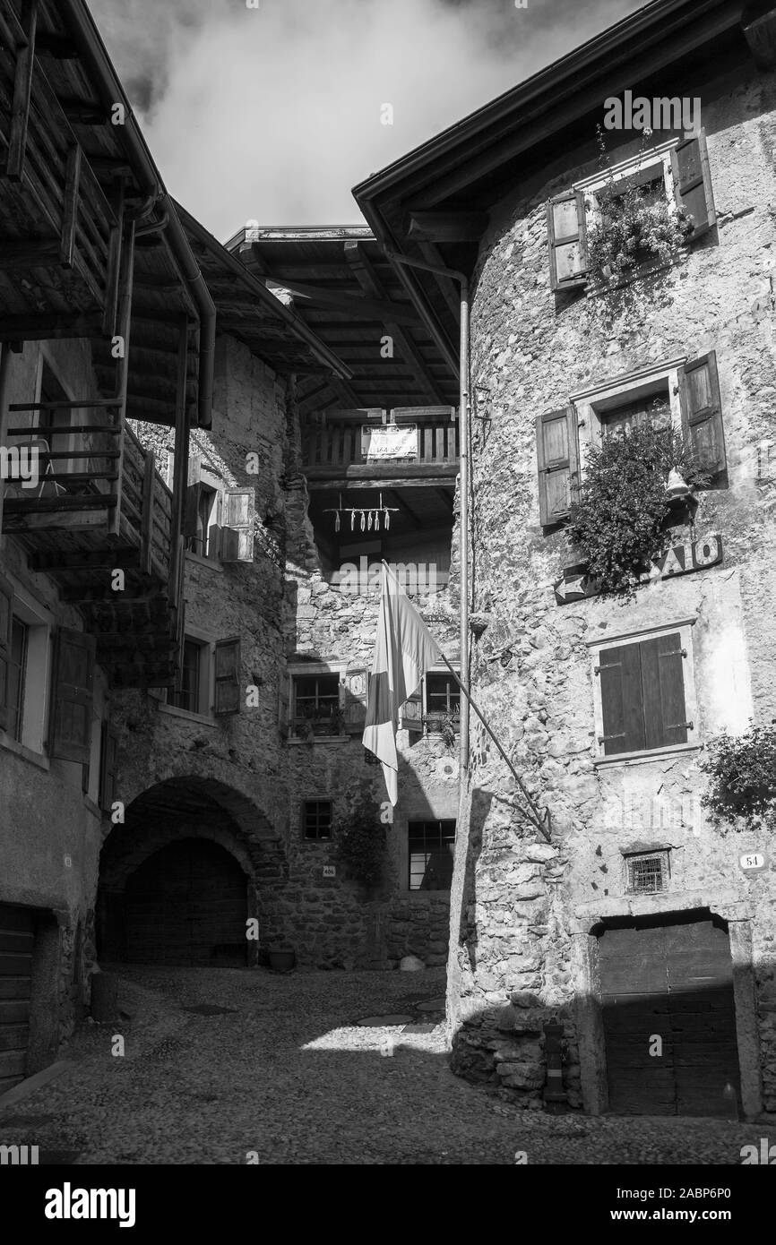Piazza Francesco Baracca, la minuscola piazza principale del borgo medioevale di Canale di Tenno, Trentino-Alto Adige, Italia. Versione in bianco e nero Foto Stock