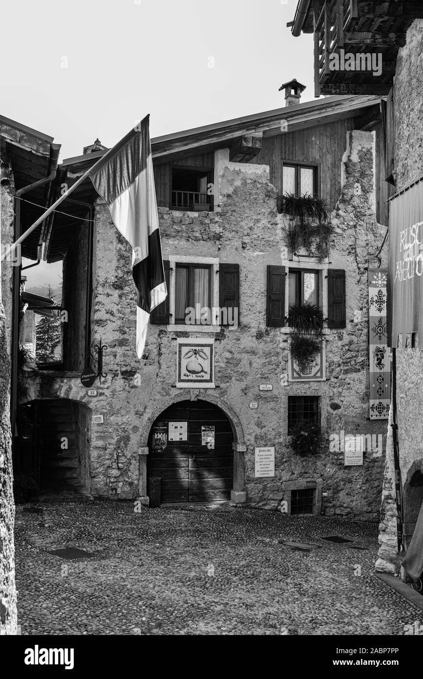 Piazza Francesco Baracca, la minuscola piazza principale del borgo medioevale di Canale di Tenno, Trentino-Alto Adige, Italia. Versione in bianco e nero Foto Stock