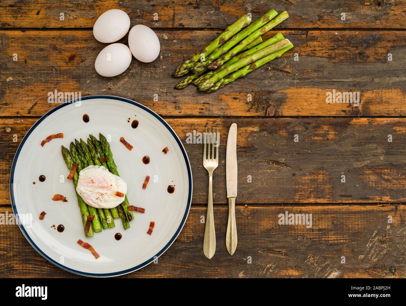 Fotografia di cibo di un Uovo affogato con gli asparagi e pancetta croccante. Foto Stock