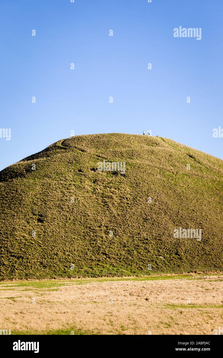 Diminutivo figure di una donna uomo e cane sulla sommità di Silbury Hill un antico monumento vicino a Marlborough Wiltshire, Inghilterra REGNO UNITO Foto Stock