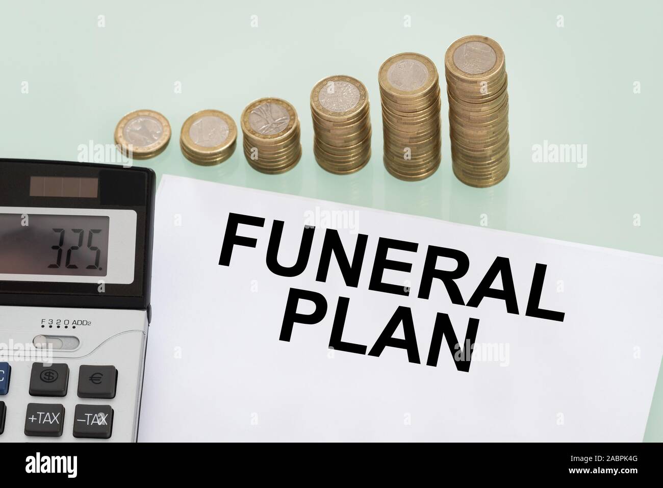 Piano funebre Papers, la pila di monete e calcolatrice Foto Stock