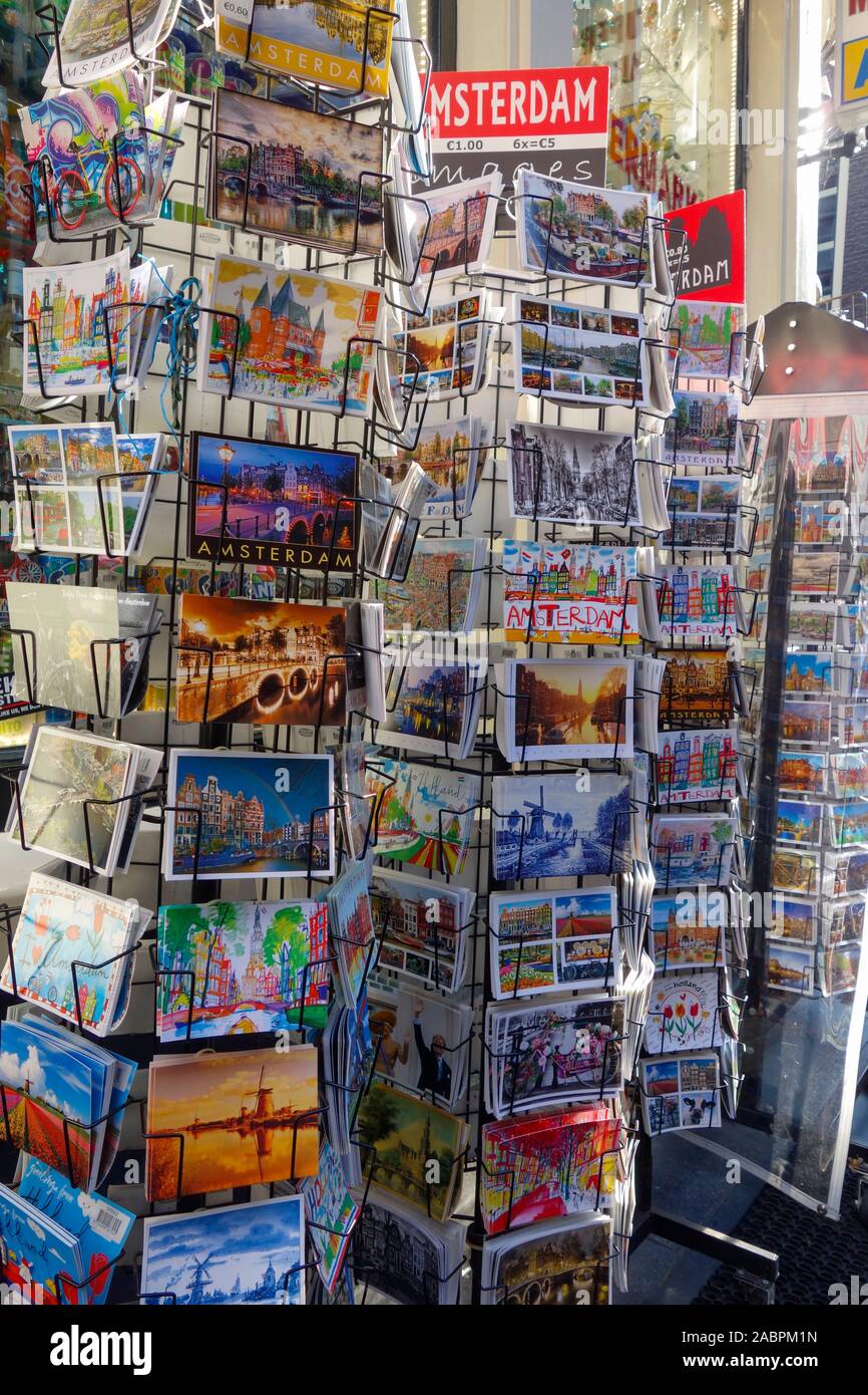 Cartoline colorate di Amsterdam in vendita in rack presso un negozio di souvenir, i Paesi Bassi. Foto Stock