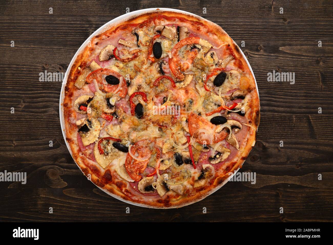 Funghi e salame piatto pizza più scuro dello sfondo in legno Foto Stock