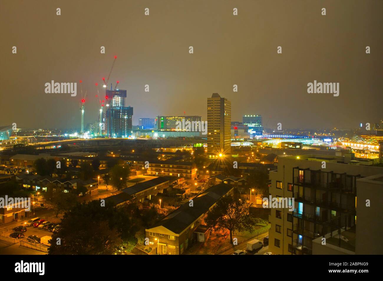 Una vista attraverso Stratford, Londra con il centro commerciale Westfield illuminato in background. Foto Stock