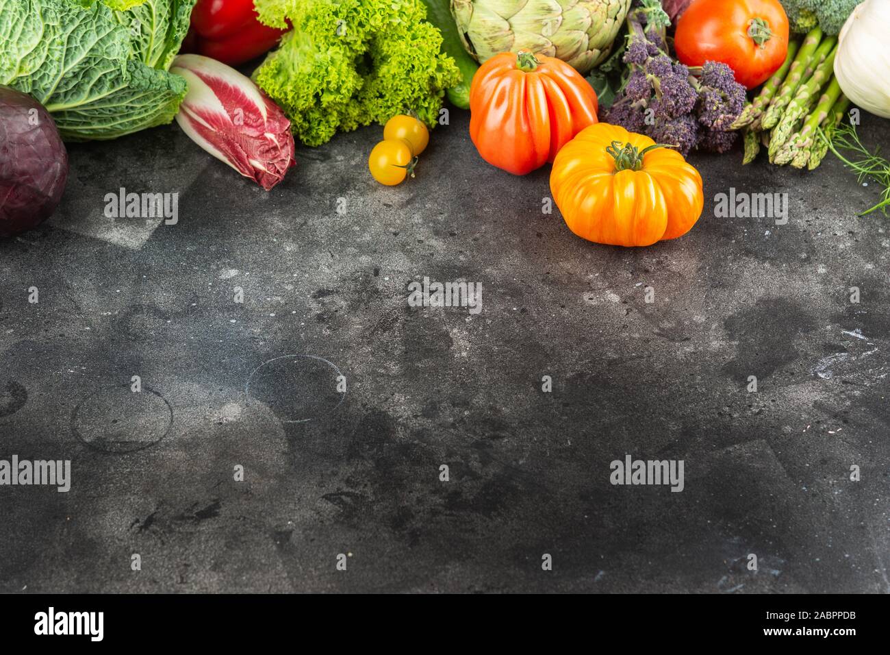Ortaggi freschi sul grigio scuro e sfondo nero, vista dall'alto, copia di spazio, il fuoco selettivo Foto Stock