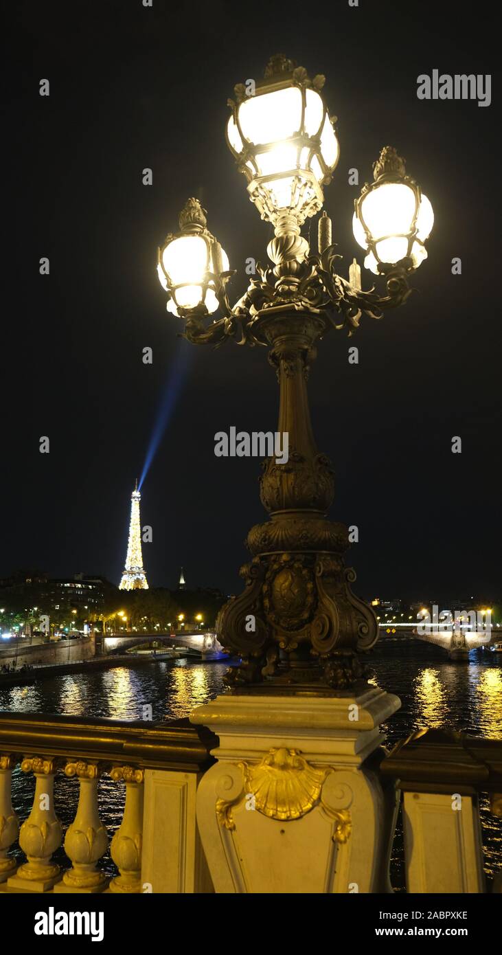 Luce della Torre Eiffel che rifulge sul ponte Alexandre III LAMPIONE Foto Stock
