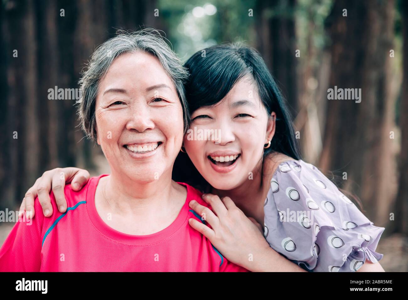 Asian senior mamma e figlia adulta sono avvolgente Foto Stock