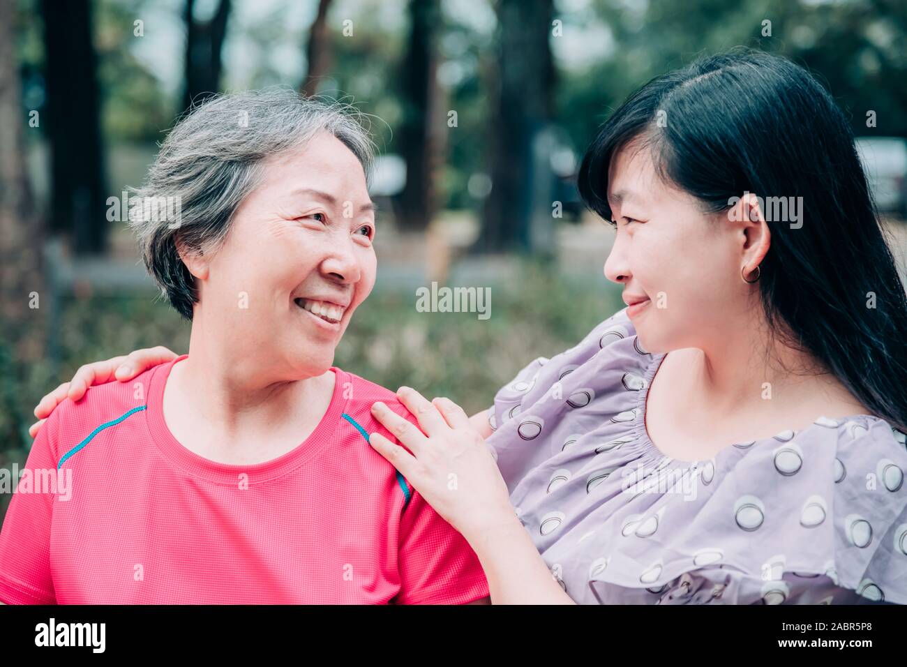 Asian senior mamma e figlia adulta sono avvolgente Foto Stock