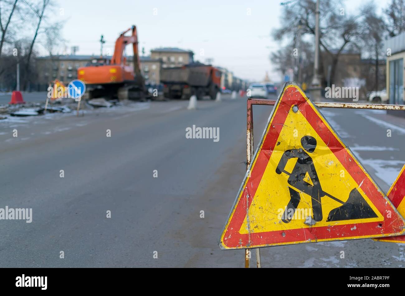 Segnaletica stradale, deviazione, riparazione su strada sullo sfondo della strada e l'escavatore che scava la fossa Foto Stock