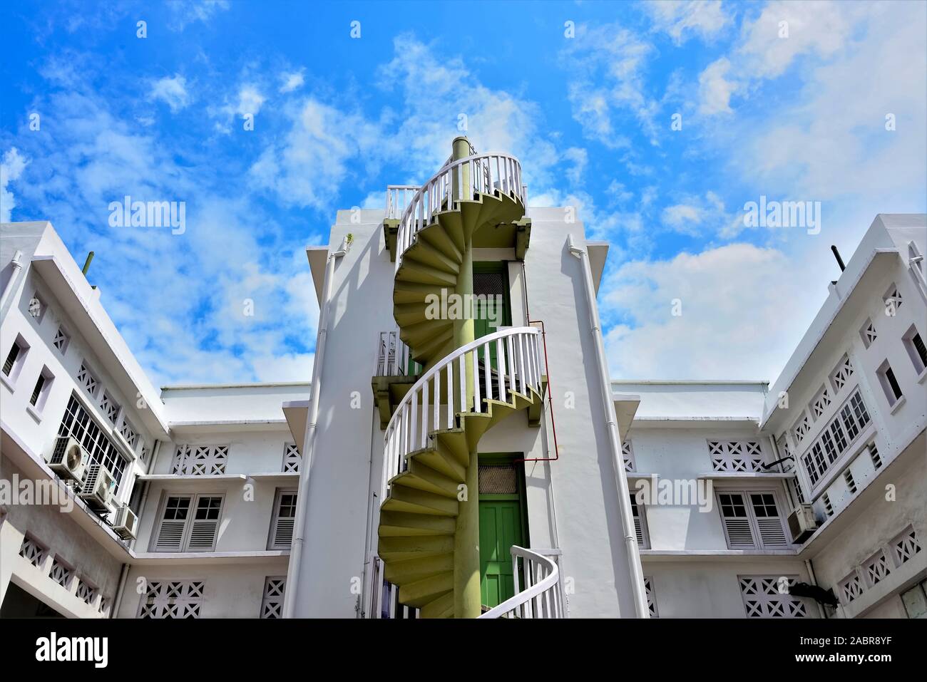 Esterno in pietra scalinata a spirale sulla facciata di Singapore townhouse contro sky in Bugis Junction, il centro cittadino di Singapore Foto Stock