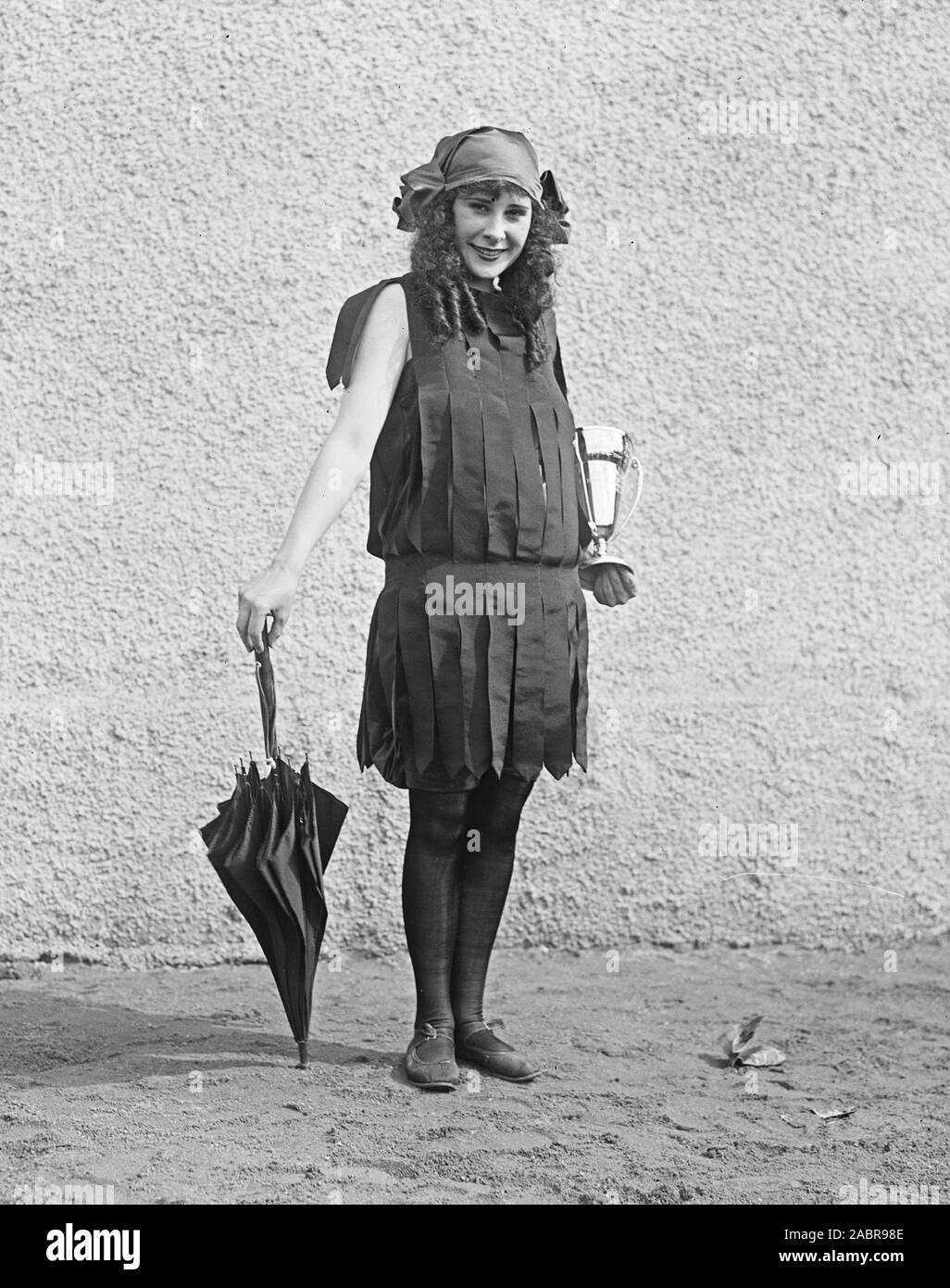Donna che indossa un costume da bagno e tenendo un trofeo cup ca. 1922 Foto Stock