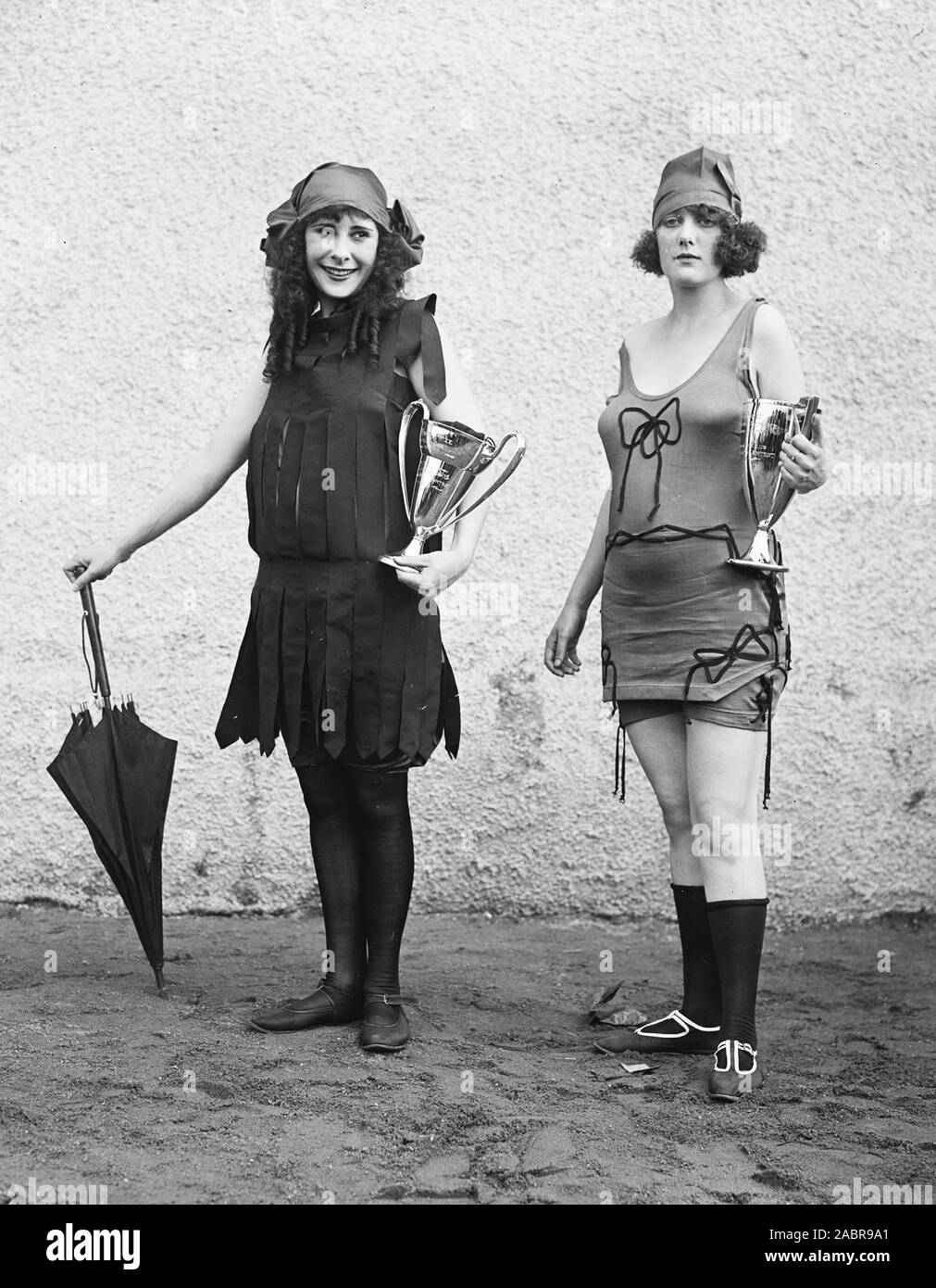 Donne che indossano i costumi da bagno e tenendo i trofei ca. 1922 Foto Stock