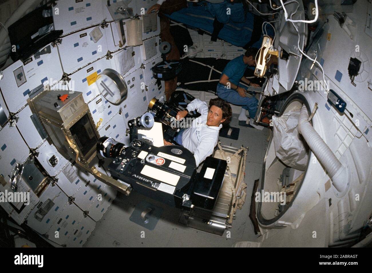 (24-29 aprile 1990) --- una fotocamera da 35mm con un "fish eye" lente catturato questo angolo di alta immagine sulla scoperta di middeck. Astronauta Kathryn D. Sullivan funziona con la fotocamera IMAX in primo piano, mentre astronauta Steven A. Hawley consulta un elenco di controllo in angolo. Un Arriflex motion picture fotocamera registra studente ione esperimento arco in apparecchiature montate su gavone di stivaggio. L'esperimento è stato il progetto di Gregorio S. Peterson, attualmente uno studente presso la Utah State University. Foto Stock