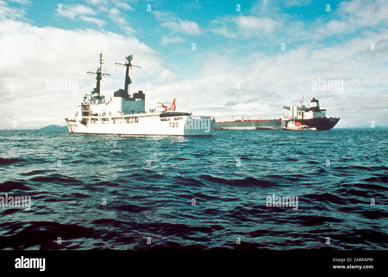 Prince William Sound, AK (Mar. 24)--Il Guardacoste Rush (WHEC 723) Le pattuglie della zona di terra il Exxon Valdez che resta nel luogo in Prince Williams Suono. La Exxon Valdez si è arenata sulla Bligh Reef in Prince William Sound, Alaska, 23 marzo 1989 la fuoriuscita di 11 milioni di galloni di petrolio greggio che ha provocato la più grande marea nera nella storia degli Stati Uniti. Foto Stock